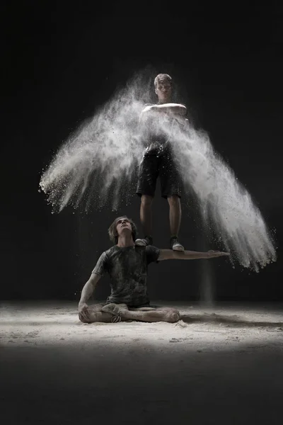 Dos jóvenes bailando en una nube de polvo blanco — Foto de Stock