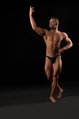 Karanlık odada yakışıklı kaslı atlet manzarası