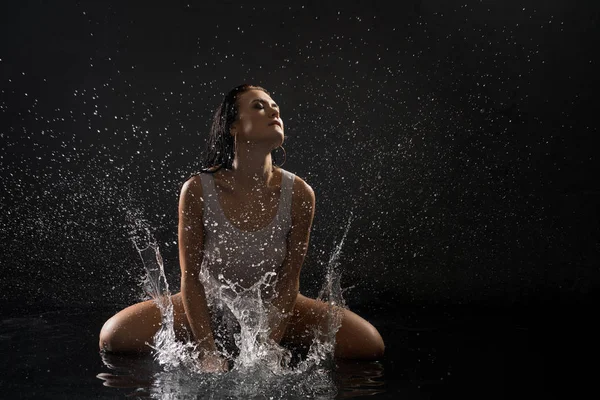 Bella ragazza che gioca con l'acqua in camera oscura — Foto Stock