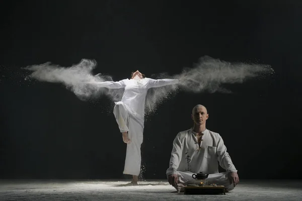 Двоє чоловіків роблять йогу в хмарі з білого пилу — стокове фото