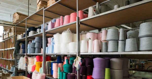 Катушки с разными цветовыми нитями на трикотажной фабрике — стоковое фото