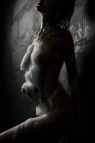 Chica desnuda y delgada con vista a la ducha contra la pared —  Fotos de Stock