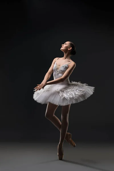 Ballerina in een witte tutu dansen in het donker — Stockfoto