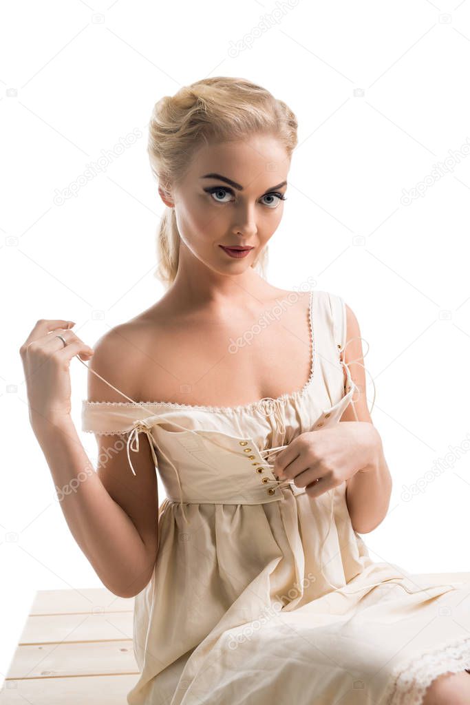 Romantic blonde in beige corset on a sofa