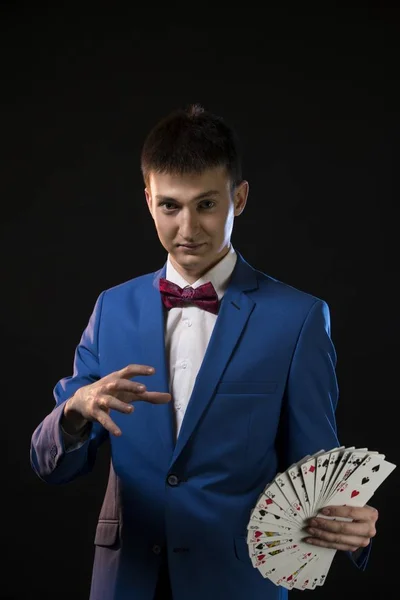 Handsome illusionist showing tricks in the dark — Stock Photo, Image