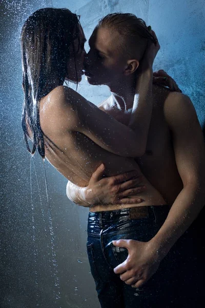 Naked couple kissing in a shower in the dark