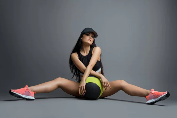 Schöne Brünette in sexy Sportbekleidung auf dem Boden — Stockfoto