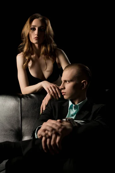 Lindo casal tiro no sofá preto à noite — Fotografia de Stock
