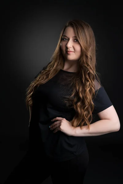 Menina bonita em t-shirt preta posando em estúdio — Fotografia de Stock