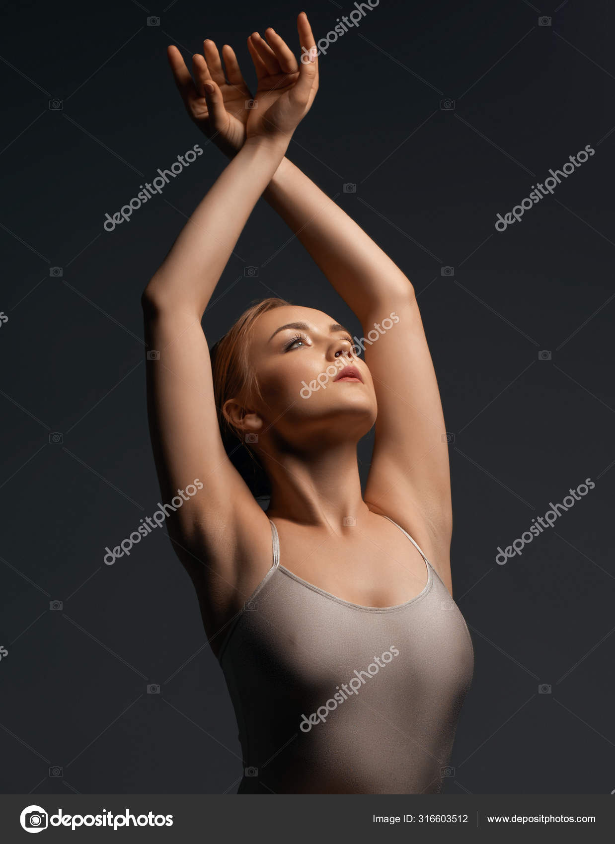 Sexy gymnast in ecru bodysuit gray background shot Stock Photo by ©Wisky  316603512