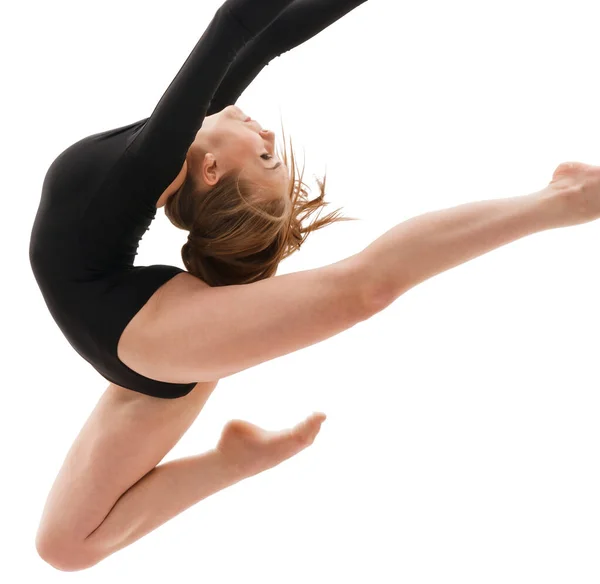 Молодая стройная гимнастка в грациозной студии прыжков — стоковое фото