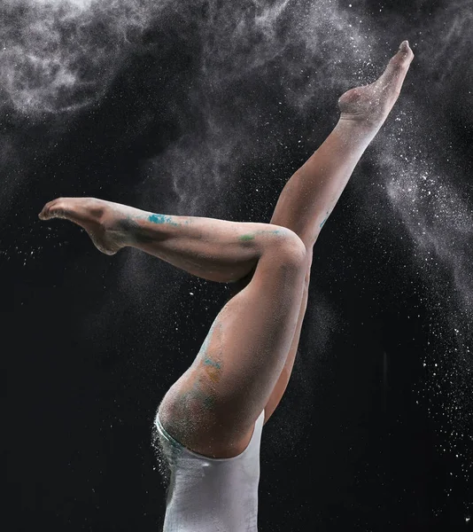 Femme mince faisant de l'exercice dans un nuage de poussière blanche — Photo