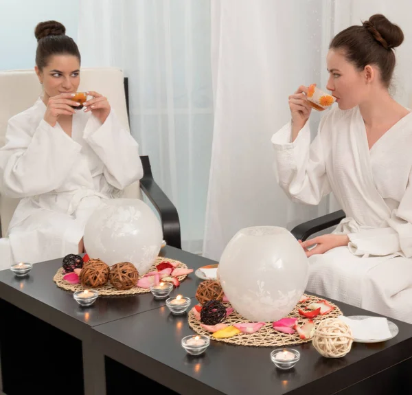 Guapas chicas jóvenes tomando un té en el salón de spa — Foto de Stock