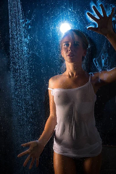 Woman in wet t-shirt in shower view in the dark