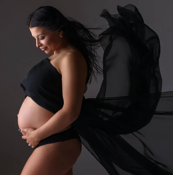 Elegante madre embarazada posa con tela voladora —  Fotos de Stock