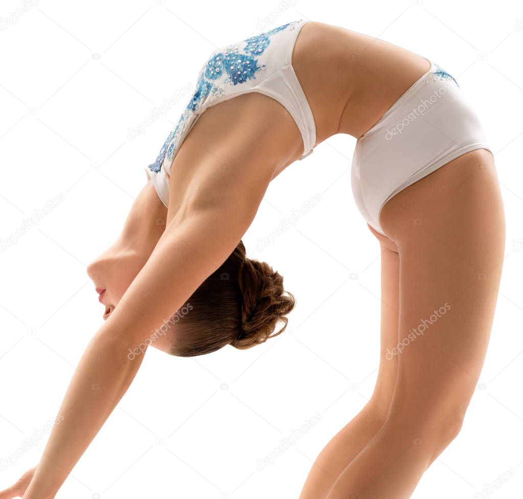 Young female gymnast making exercises in studio