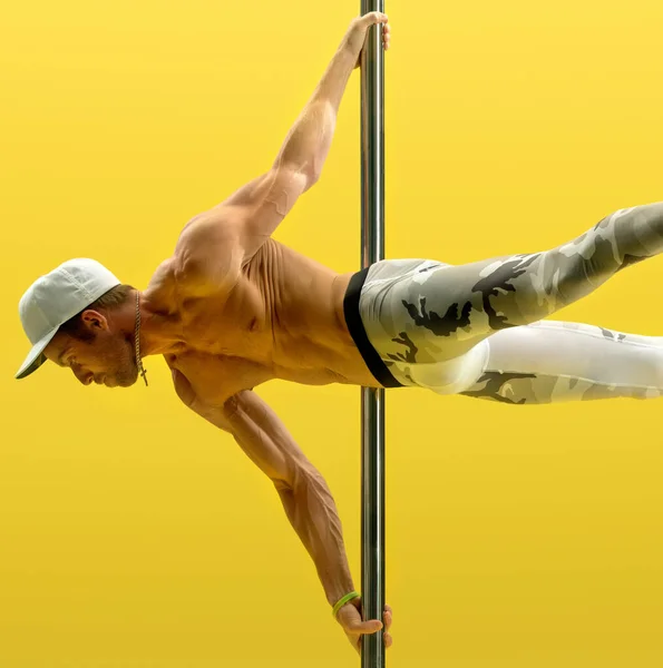 Studio photo of acrobat exercising on pole — Stock Photo, Image