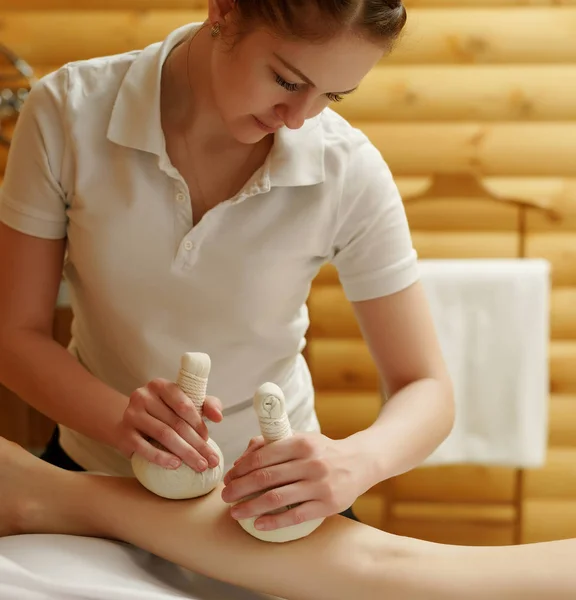 Massagista fazendo massagem tailandesa com sacos de sal — Fotografia de Stock