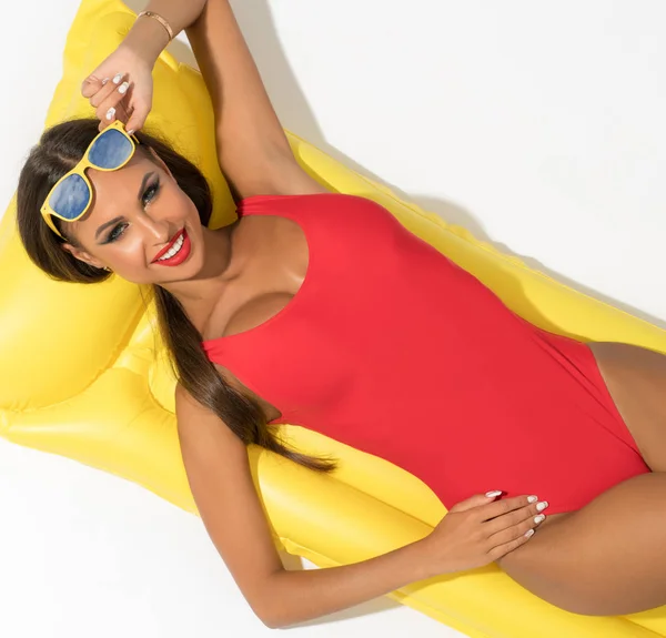 Sexig tjej på simning madrass i studio — Stockfoto