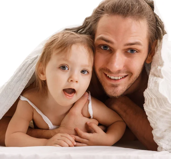 Knappe vader en zijn kleine kind in bed liggen — Stockfoto