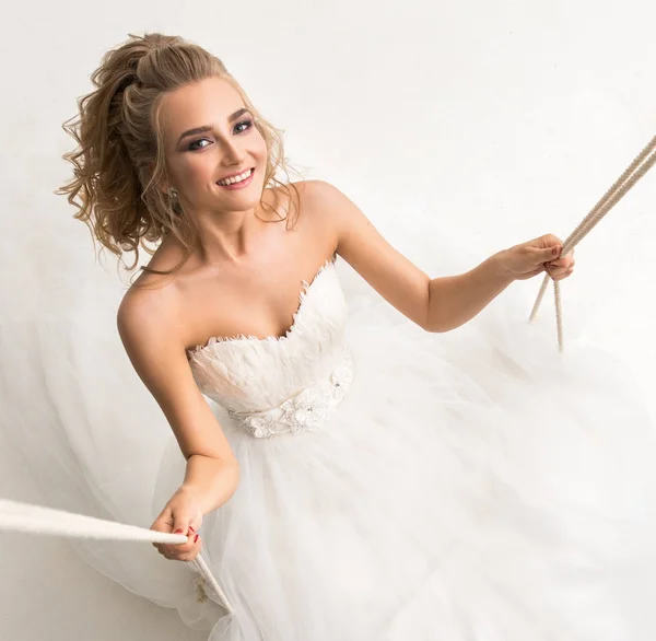 Beautiful bride posing on a swing shot from above — Stock Photo, Image