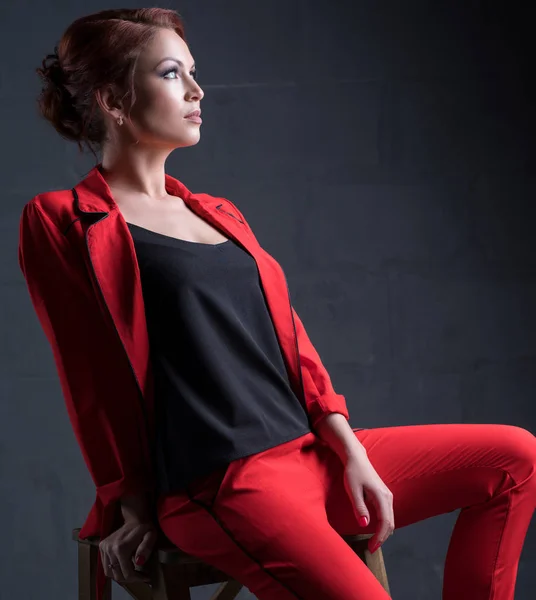 Frau im modischen roten Strumpfanzug im Studio — Stockfoto