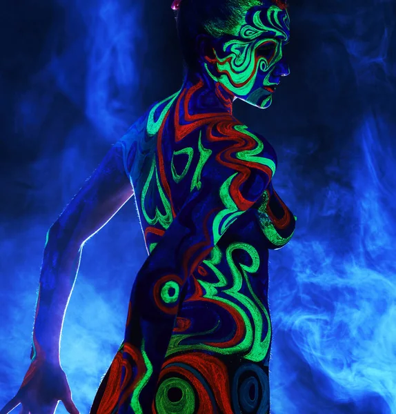 Rear view of naked girl with body art in UV light — Stock Photo, Image