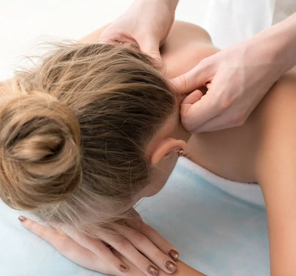 Jovem loira desfrutando de massagem no pescoço no salão — Fotografia de Stock