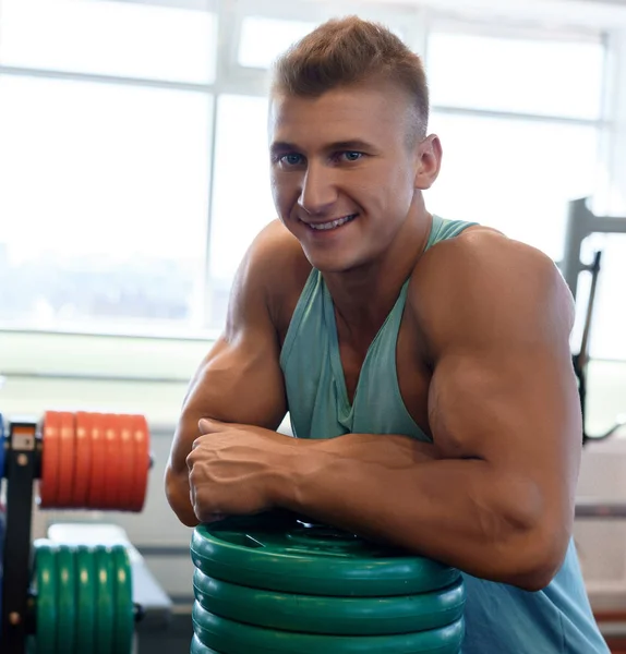 Junge hübsche Bodybuilder posiert in einem Fitnessstudio — Stockfoto