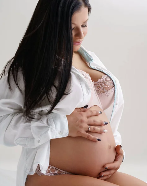 Mulher grávida de cabelos escuros posando em estúdio — Fotografia de Stock