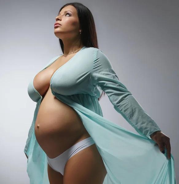Piękne kobiety w ciąży, pozowanie w szlafrok — Zdjęcie stockowe