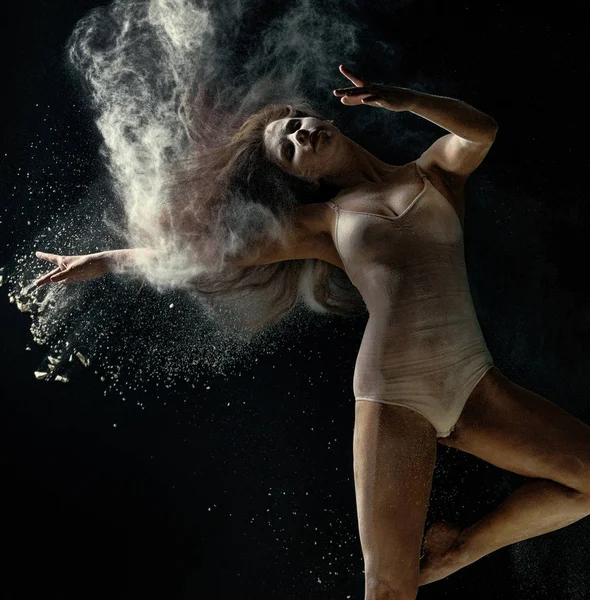 Удивительное фото грациозной женщины, танцующей с пылью — стоковое фото