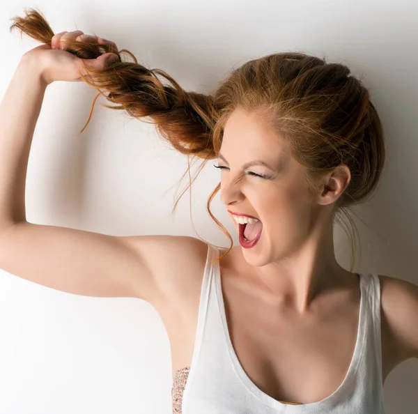 Cute girl screaming and pulling herself pigtail — Stock Photo, Image