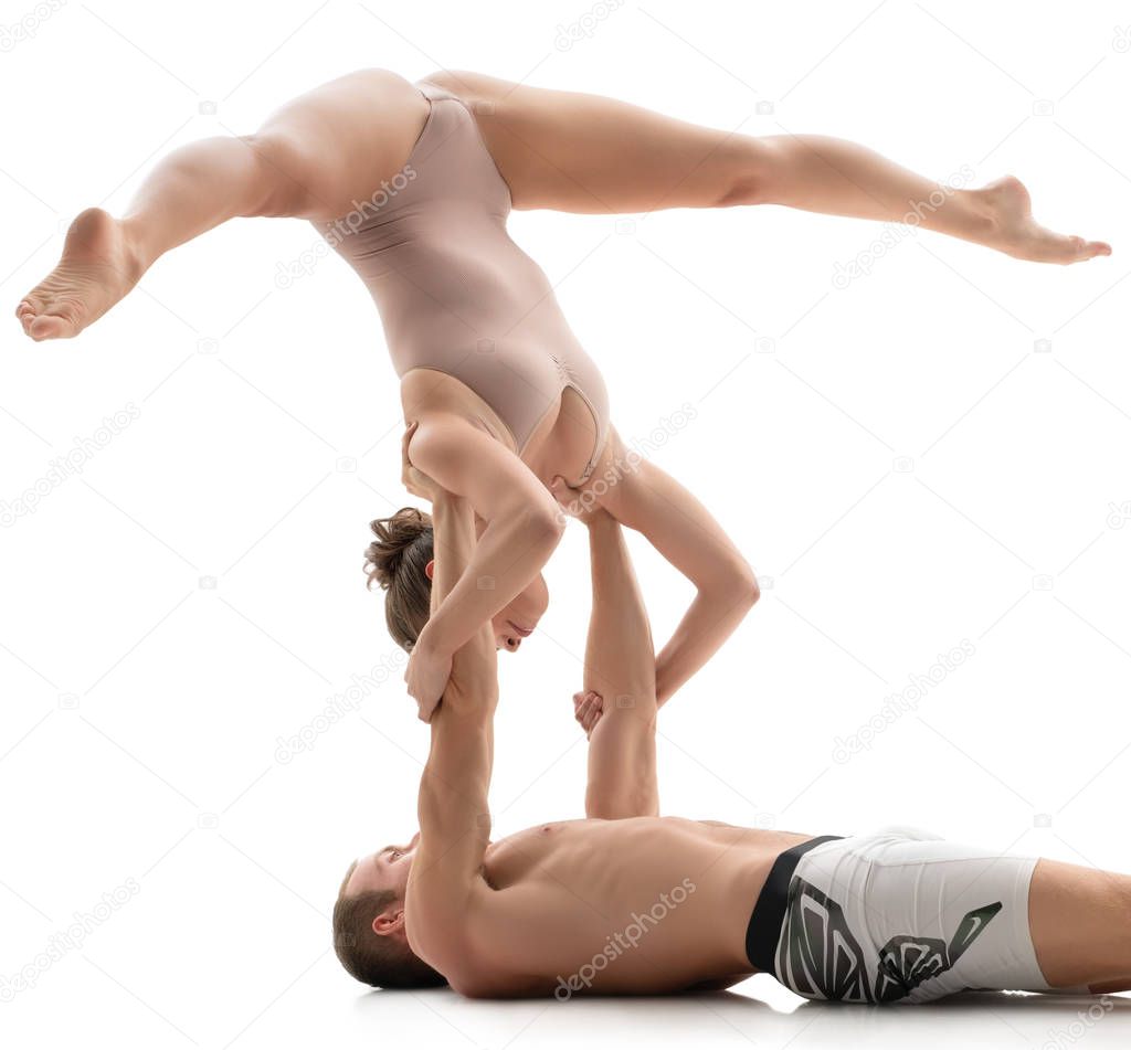 Acrobatic duo trains in studio. Isolated on white