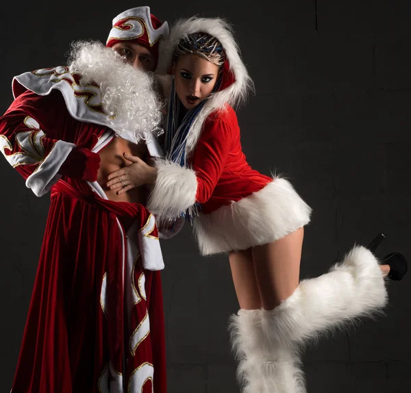 Sexy doncella de nieve coqueteando con Santa Claus —  Fotos de Stock