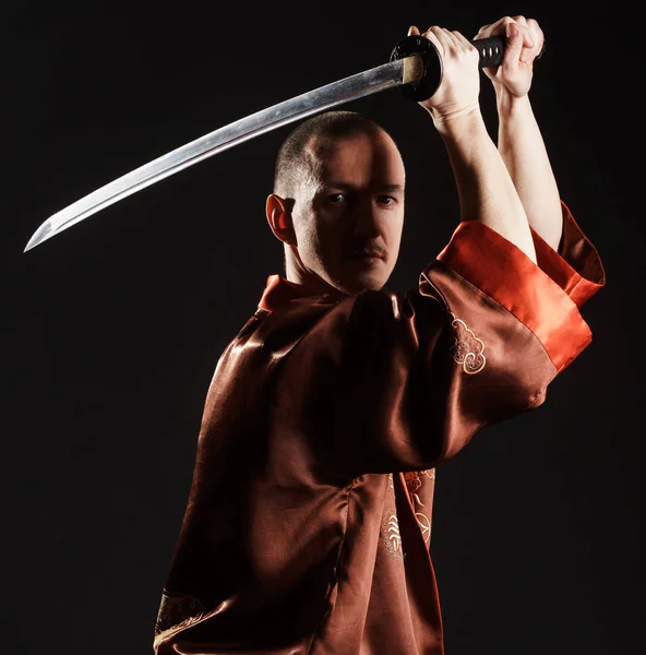 Homme en costume chinois avec épée studio portrait — Photo