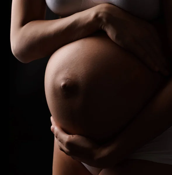 Крупный план беременной женщины, держащей живот — стоковое фото