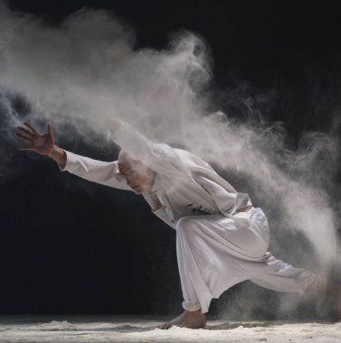 Male doing yoga in white dust cloud - concept of power