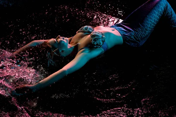 Woman in mermaid image lying in water dops shot — Stock Photo, Image