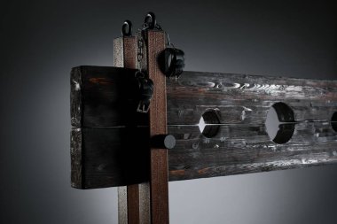 Handcuffs hanging on pillory for BDSM session clipart