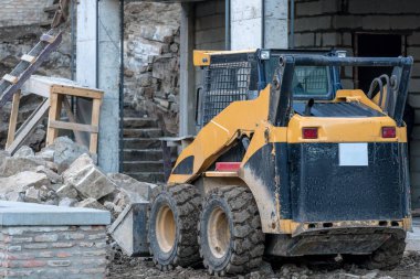 Patinaj yükleyicisi inşaat üzerinde çalışıyor.