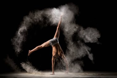 Strong man dancing in circle of sand