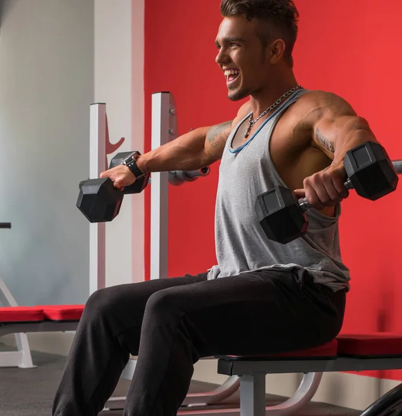 Atleta alegre haciendo ejercicio con pesas en el gimnasio —  Fotos de Stock