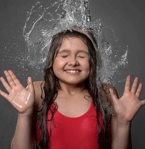 Teenage girl catching water stream from top — Stock Photo, Image