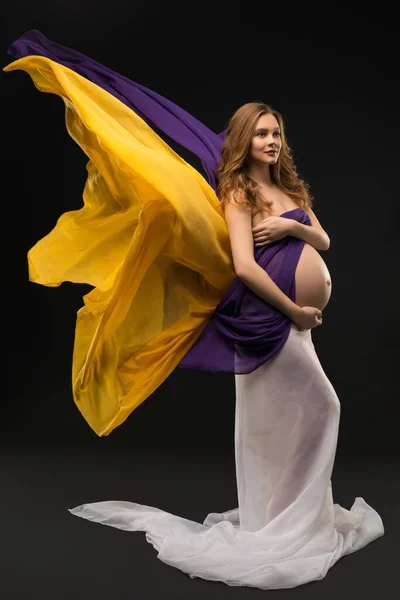 Těhotná žena střílel proti černé pozadí — Stock fotografie