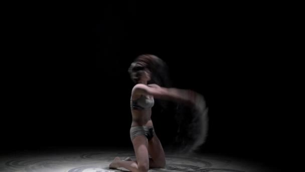 Девушка выбрасывает пыль в темноте — стоковое видео