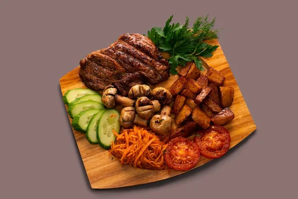 Свежий стейк с овощами и салатом — стоковое фото