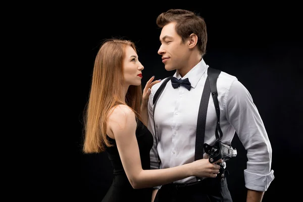 Young couple profile shot with gun in the dark — Stock Photo, Image