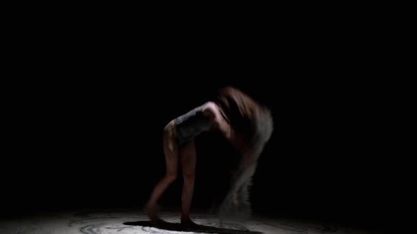 Gracieuze danseres springen met stof in het donker — Stockvideo
