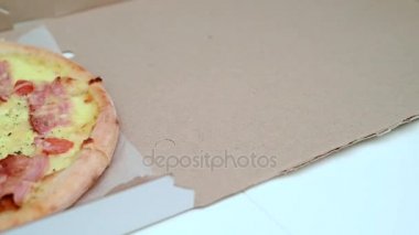 karton kutu ve bir parça alarak eller yarım pizza